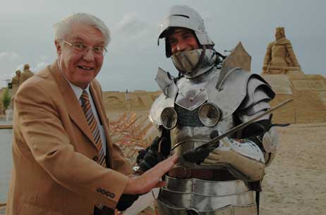 Ist das Schwert auch scharf? Lübecks Wirtschaftssenator Wolfgang Halbedel prüft die Klinge eines Sand-World-Ritters. Monate später muss er das Ende der Veranstaltungsreihe verkünden. Foto: HELGE NORMANN