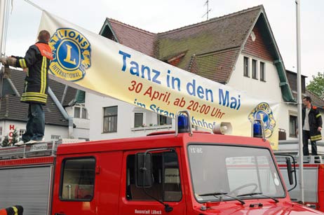 Die FFW Travemünde brachte das Banner zum »Tanz in den Mai« im Strandbahnhof in der Bertlingstraße an. Foto: <b>TA</b>