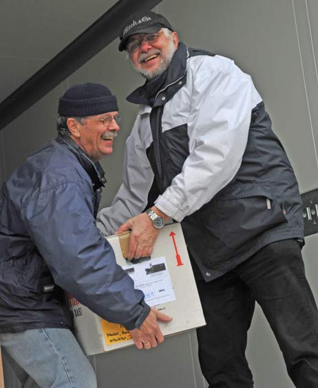 Pastor i.R. Helmut Brauer (rechts) und Helfer Volker Zengel laden die Kartons mit Kleidern und Schuhen auf den Lastwagen. Foto: <b>TA</b>