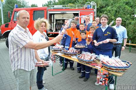 Ortswehrführer Martin Grage, Detlef Payk und die Jugendfeuerwehr der FFW Travemünde freuten sich, dass viele Kunden (links) bei der Mettwurst zugriffen. Foto: <b>TA</b>