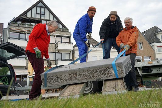 Rolf Stahr (2.v.l.) stemmt mit Hilfe des Kunstvereins den Sockel für seine »Feder« vom Anhänger. Foto: <b>TA</b>