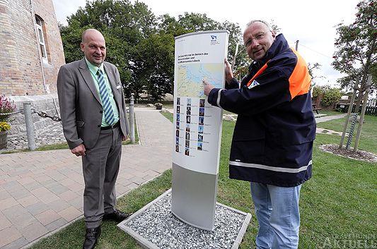 Der Bürgermeister der Stadt Fehmarn (links), Jörg Weber und der Leiter des Wasserstraßen- und Schifffahrtamtes in Lübeck Henning Dierken enthüllen eine Infostele. <b>Foto Karl Erhard Vögele</b>