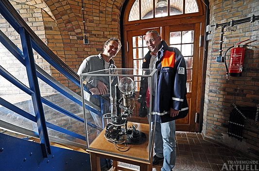 Der Leiter des Wasserstraßen- und Schifffahrtamtes Lübeck, Henning Dierken, übergab dem Leuchtturmpächter Hannes Leichsering (links) die museumswürdige Kostbarkeit einer »Lichtquellenwechselvorrichting«, die bei Bedarf das Licht des Leuchtturmes von elektrischem Licht auf ein gasbetriebenes Licht umschalten konnte. <b>Foto Karl Erhard Vögele</b>