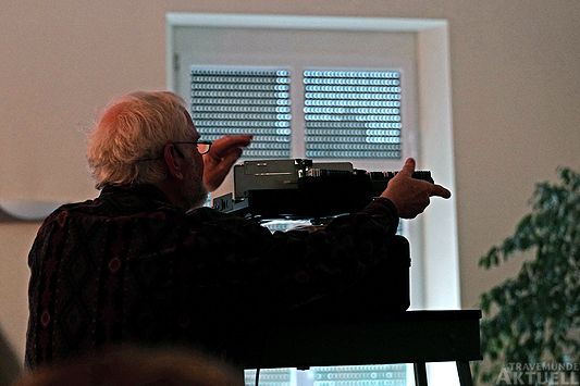 Wolf-Rüdiger Ohlhoff mit seinem unverwechselbaren Equipment. Als Vortragender z.B. während der Veranstaltung »Travemünde Jazzt« spielt er in den Umbaupausen mit einem Originalplattenspieler der 60er aus seiner wertvollen Schellackplattensammlung historische Jazzaufnahmen vor. Hier benutzt er einen Original Leitz Diaprojektor, auch ein Klassiker aus den 60er Jahren. Es ist natürlich ab und an der Wechsel eines Magazins notwendig, damit es weitergehen kann. <b>Foto Karl Erhard Vögele</b>